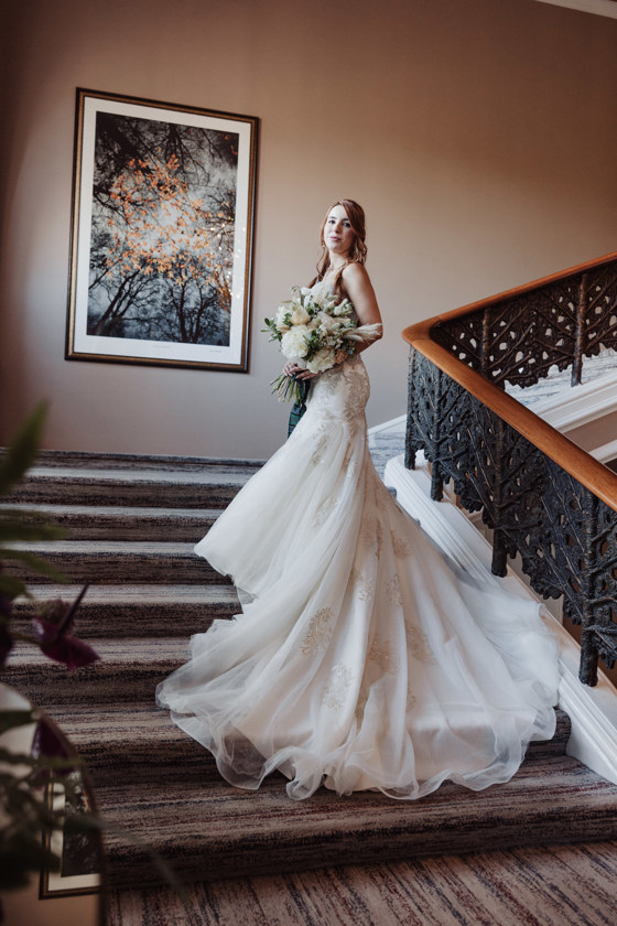 Bride poses on stairs at Dean Banks at The Pompadour